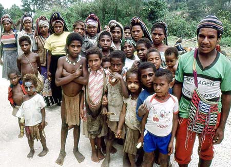 A group of Papua New Guineans crowd around a cyclist
